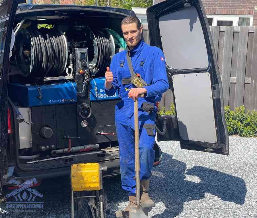 Een monteur bij de werkbus met grote hogedruk-slanghaspels, apparatuur voor hardnekkige afvoerverstoppingen in Beverwijk