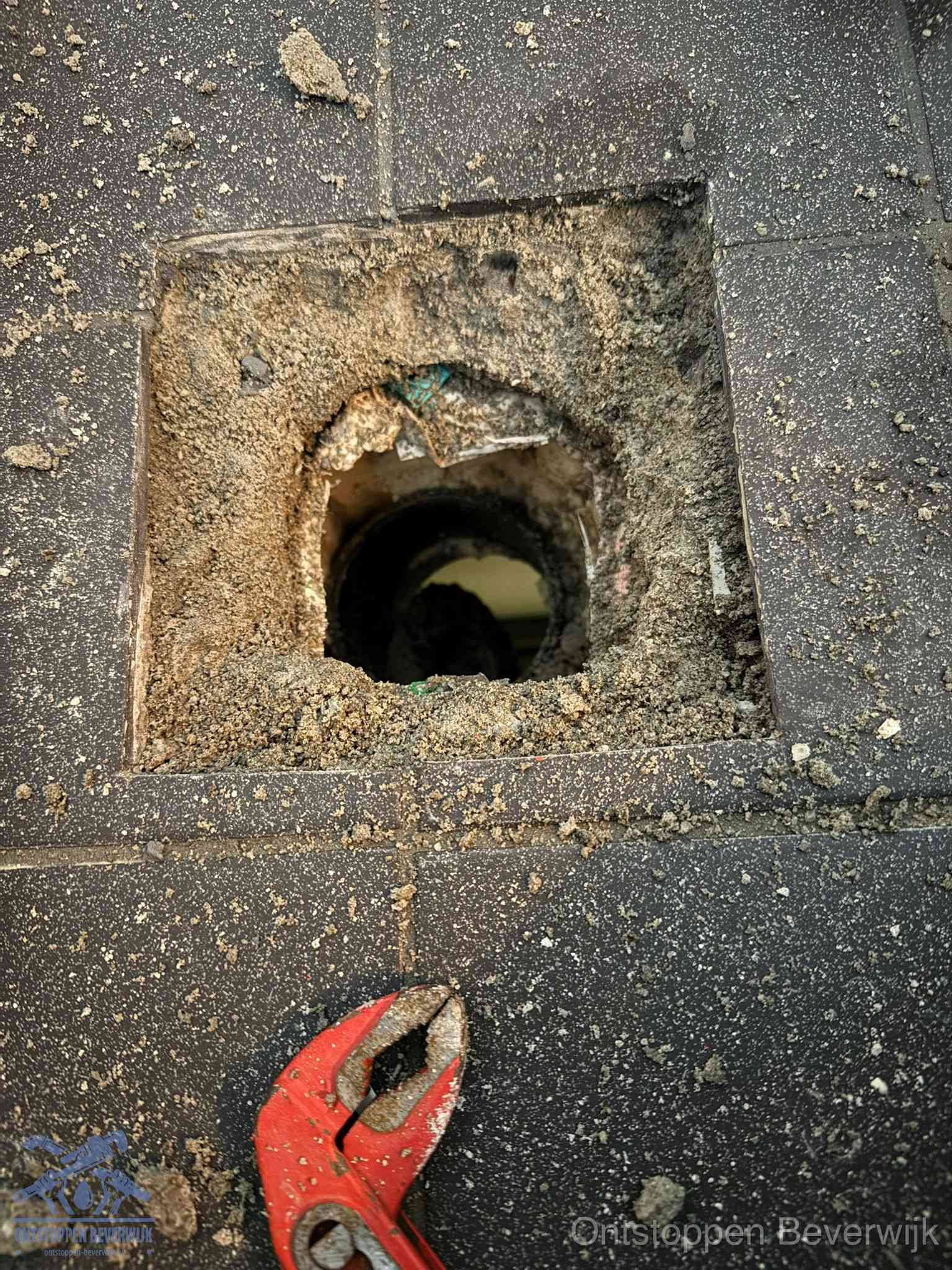 Geopend rioolputje op de erfgrens dat laat zien wie eigenaar is van de riolering in Beverwijk