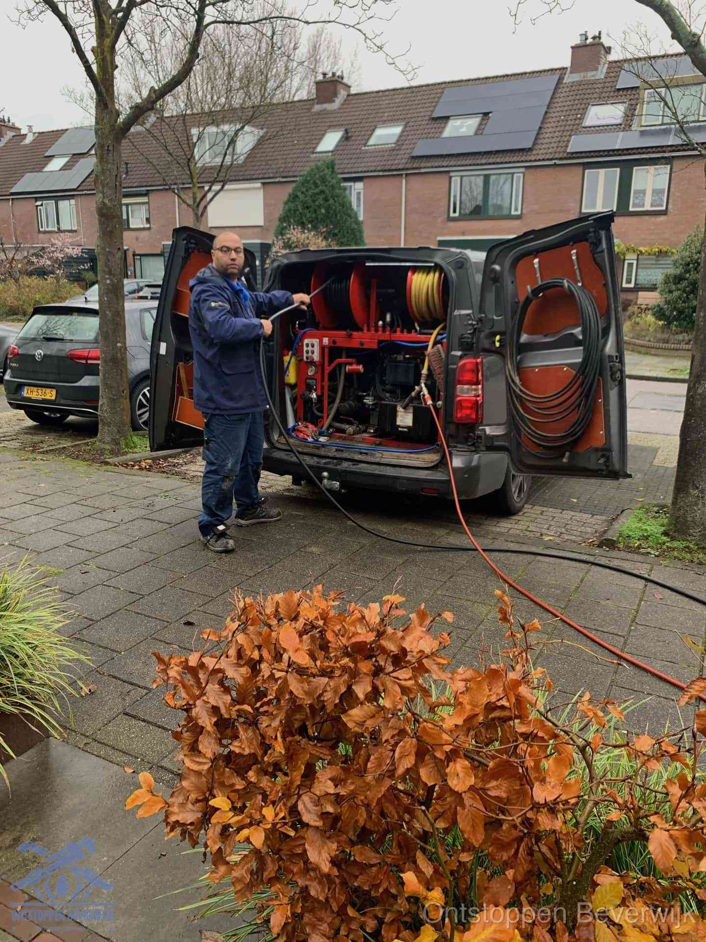 Monteur met rioolreinigingsbus levert rioolservice in de wijk in Beverwijk