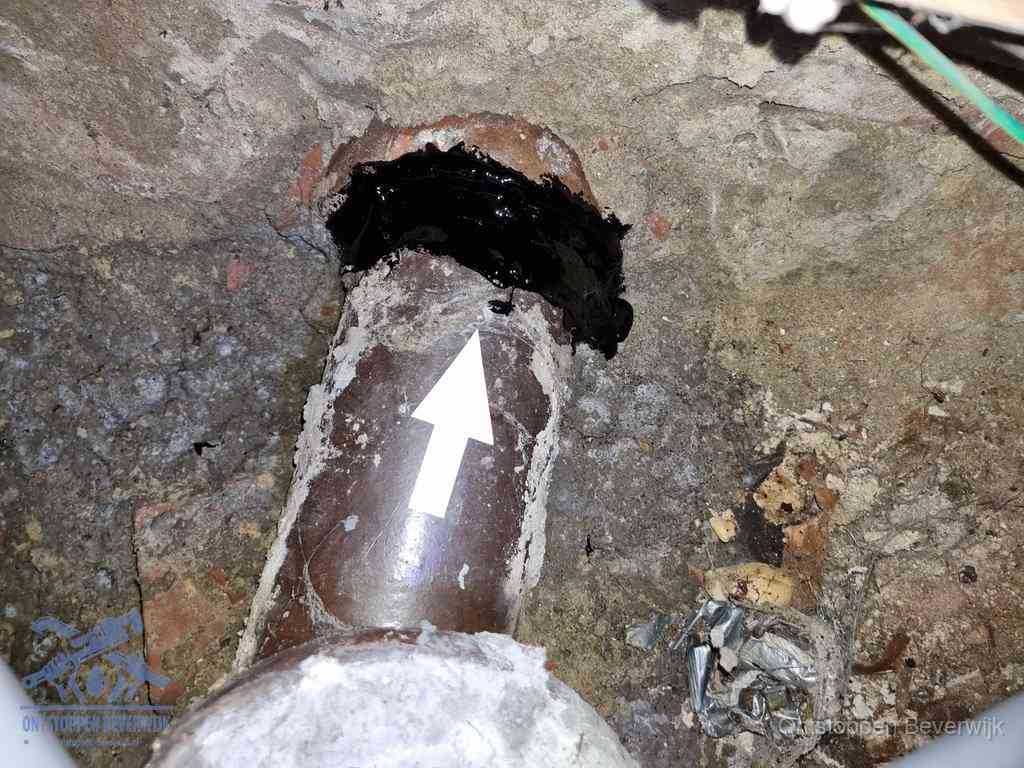 Een oude gres rioolbuis met een beschadigde koppeling onder de vloer, oorzaak van terugkerende structurele wc-problemen in Beverwijk