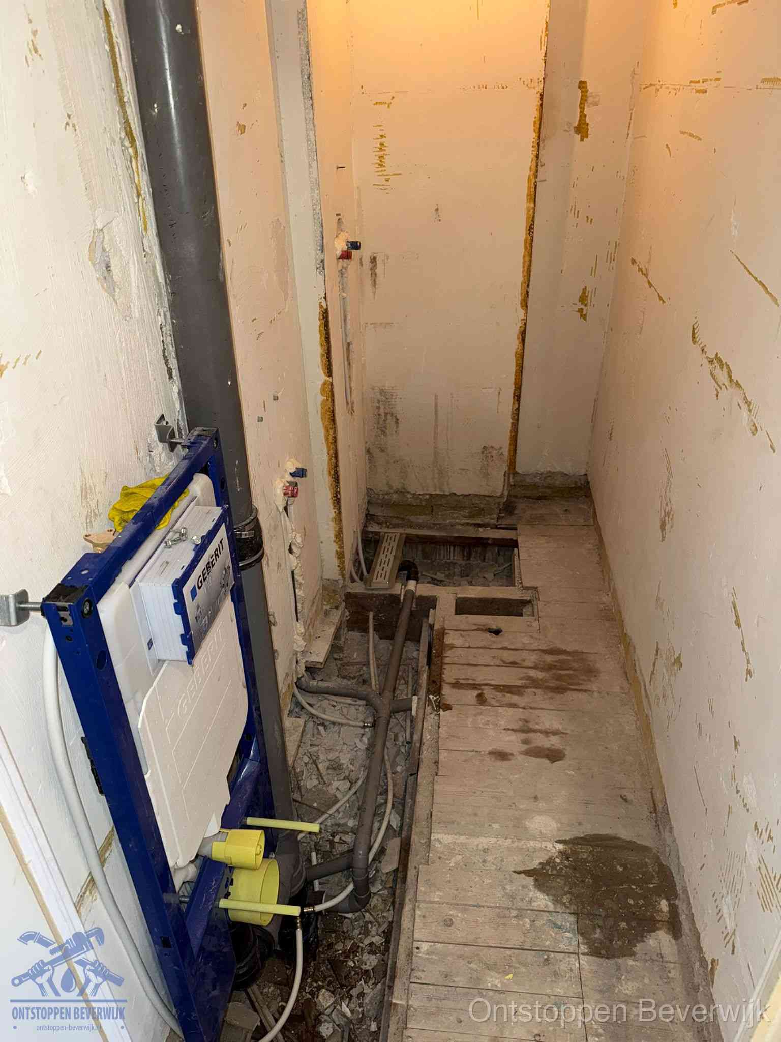 Een opgebroken toiletruimte tijdens renovatie met een Geberit inbouwreservoir en blootliggende oude afvoerleidingen, typisch voor oudere woningen in Beverwijk
